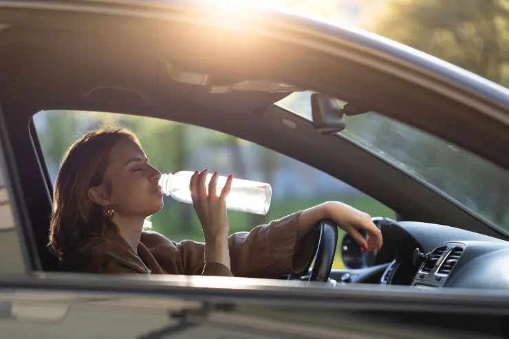 3 Mujer bebiendo agua en su coche