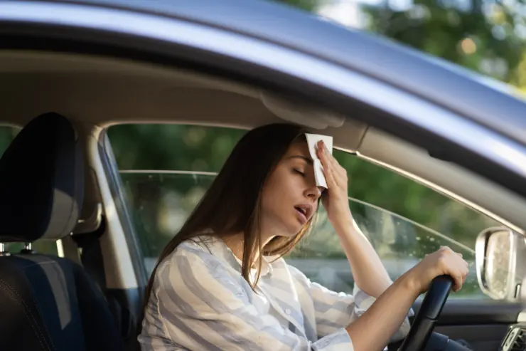 4 Mujer sudando de calor en el interior de su coche