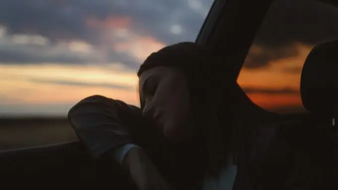 Persona durmiendo por la noche en su coche