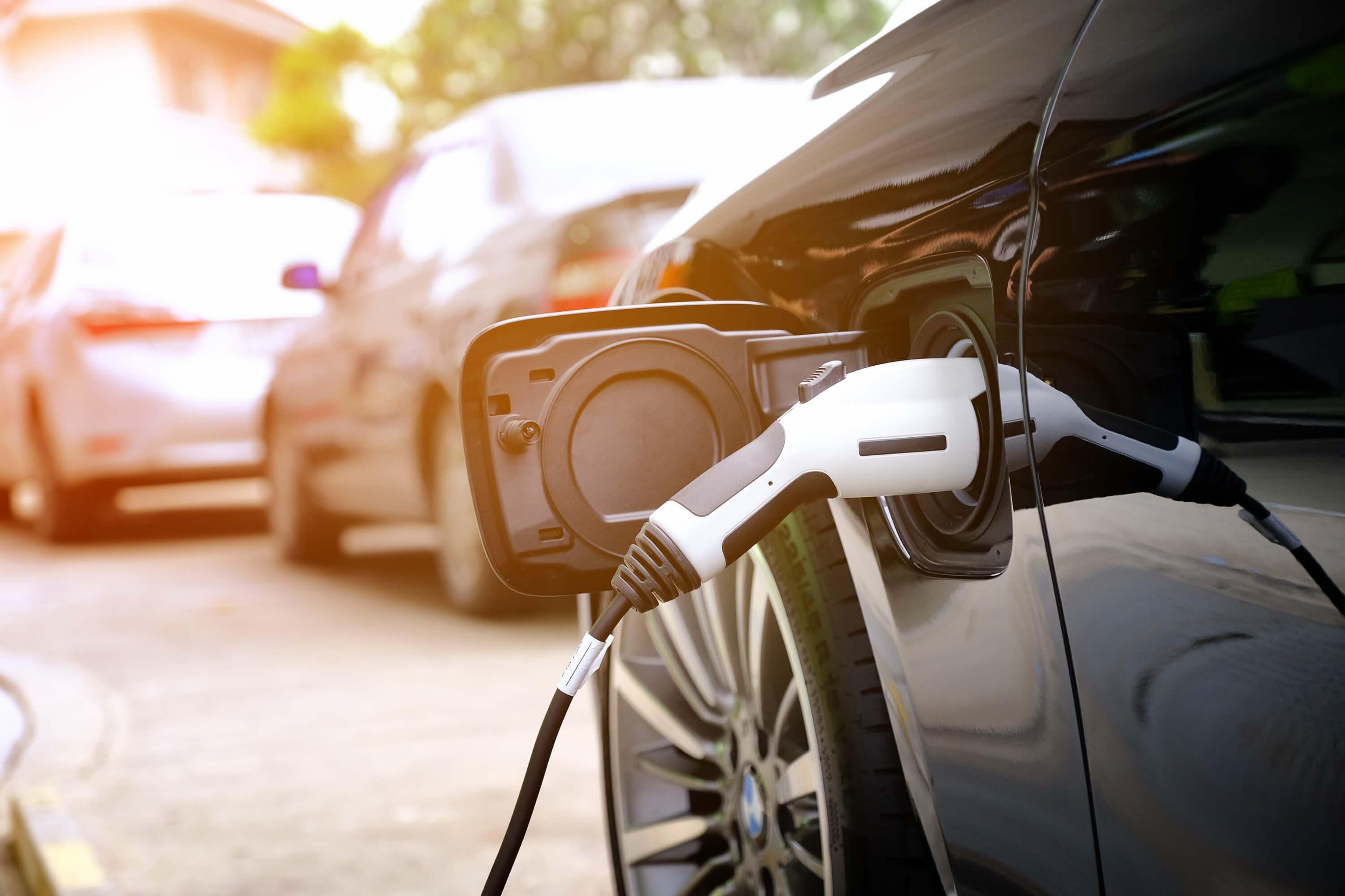 coche eléctrico enchufado en la calle con otros más