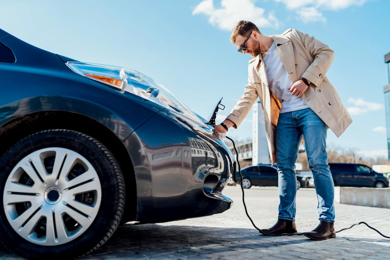 Hombre cargando su coche híbrido enchufable